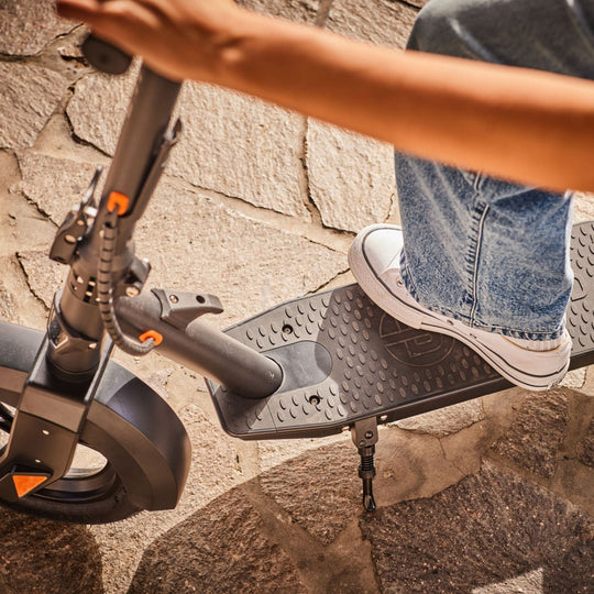 lady placing her foot on the deck pad of a blvd elite electric scooter