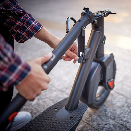 man folding down a blvd elite electric scooter